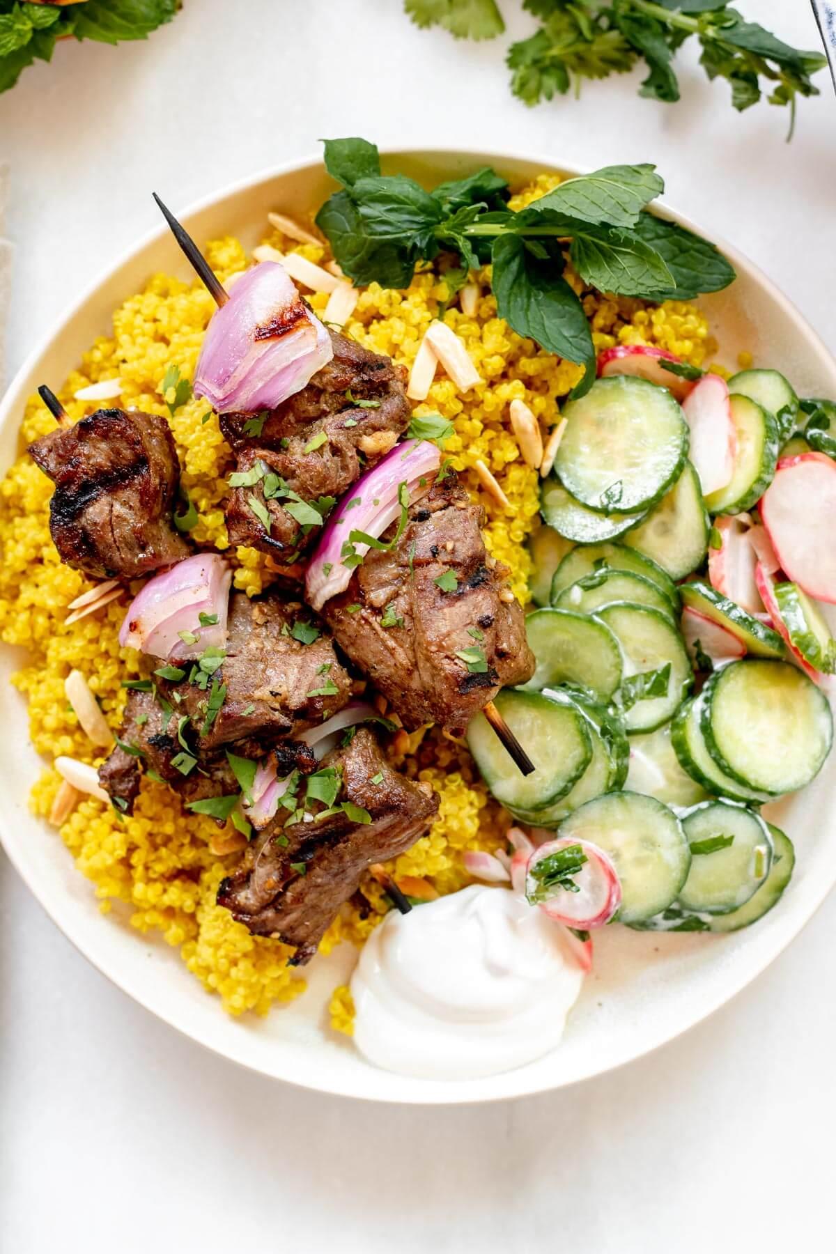 Lemon rosemary rice with grilled lamb kebabs on a wooden table