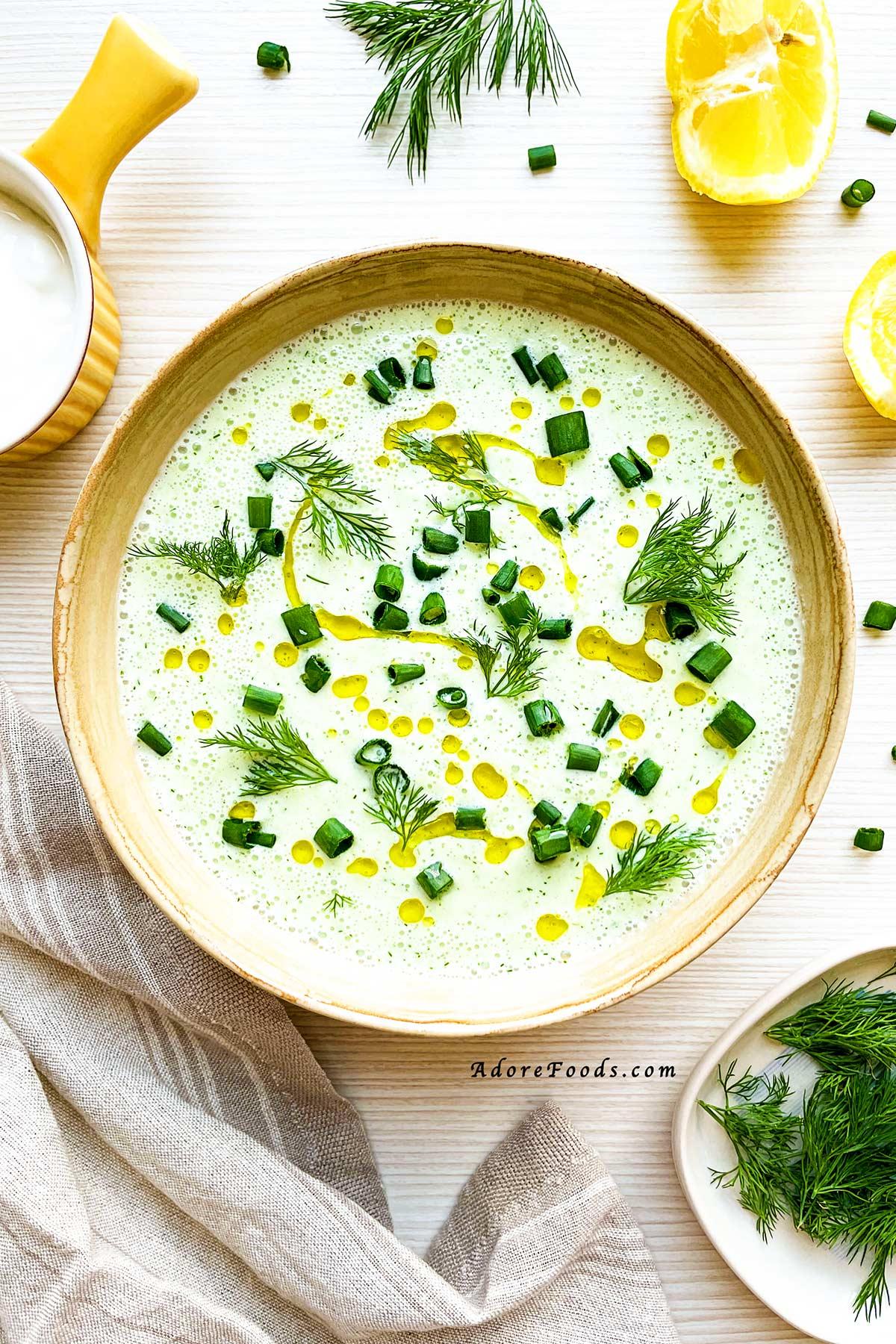 close up of a bowl of cucumber and greek yogurt gazpacho with garnishes