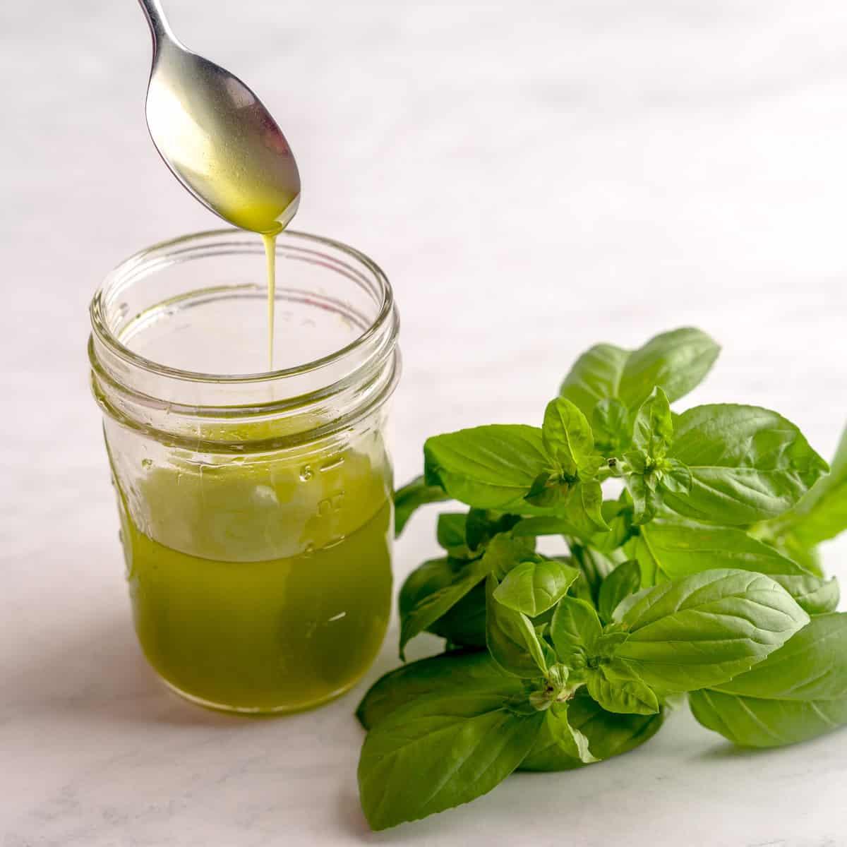 homemade basil infused avocado oil in glass jar