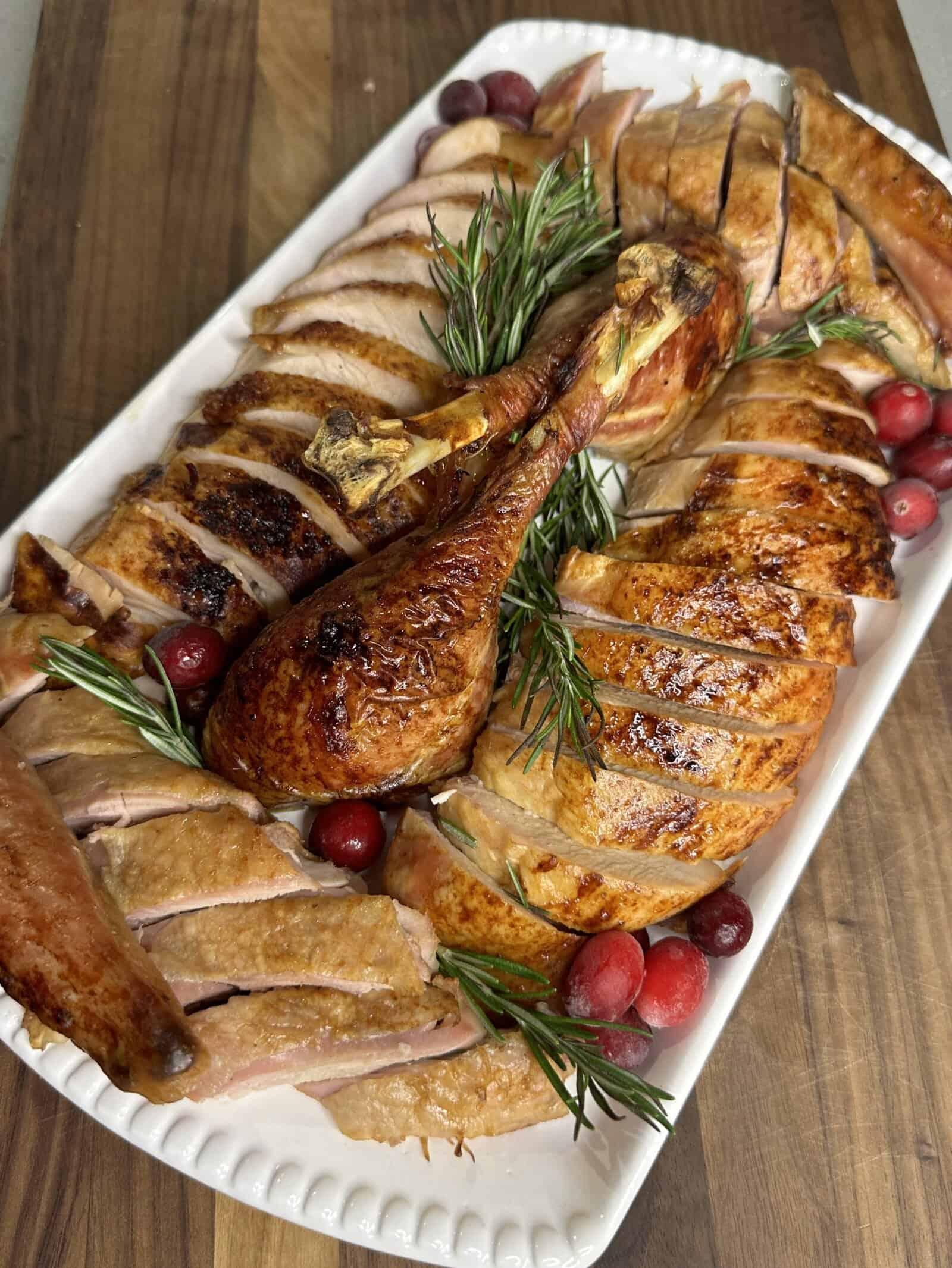 vintage cookbook open to a turkey recipe with a proud but slightly dry roasted turkey breast on a rustic wooden table with a carving set