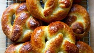An assortment of freshly baked soft pretzels on a cooling rack