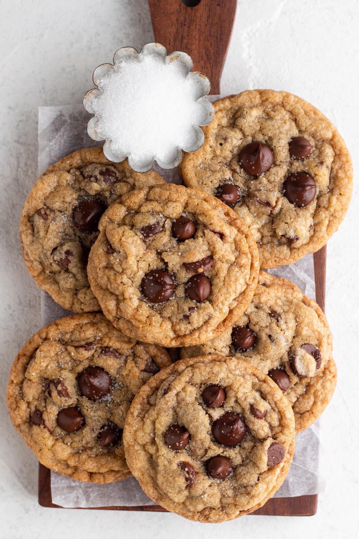 overhead shot of freshly baked chocolate chip cookies on a wooden board