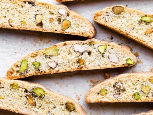A batch of plantain and pistachio biscotti on a rustic wooden table