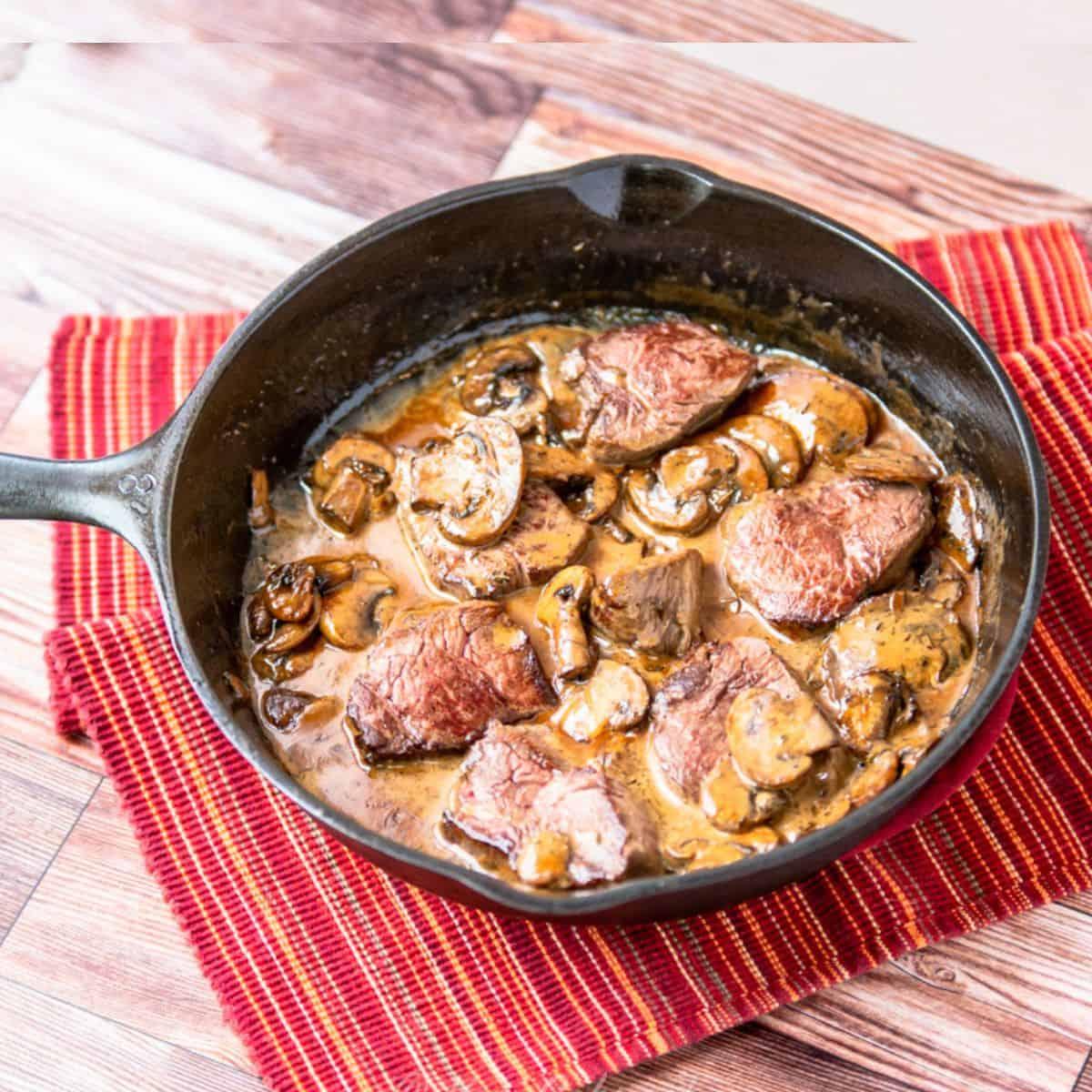 close-up of elk medallions with sauerkraut in a skillet