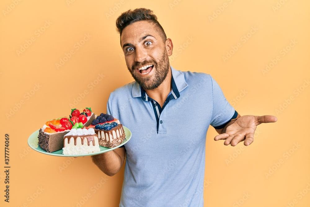 A person smiling while holding a slice of Kit Kat cake
