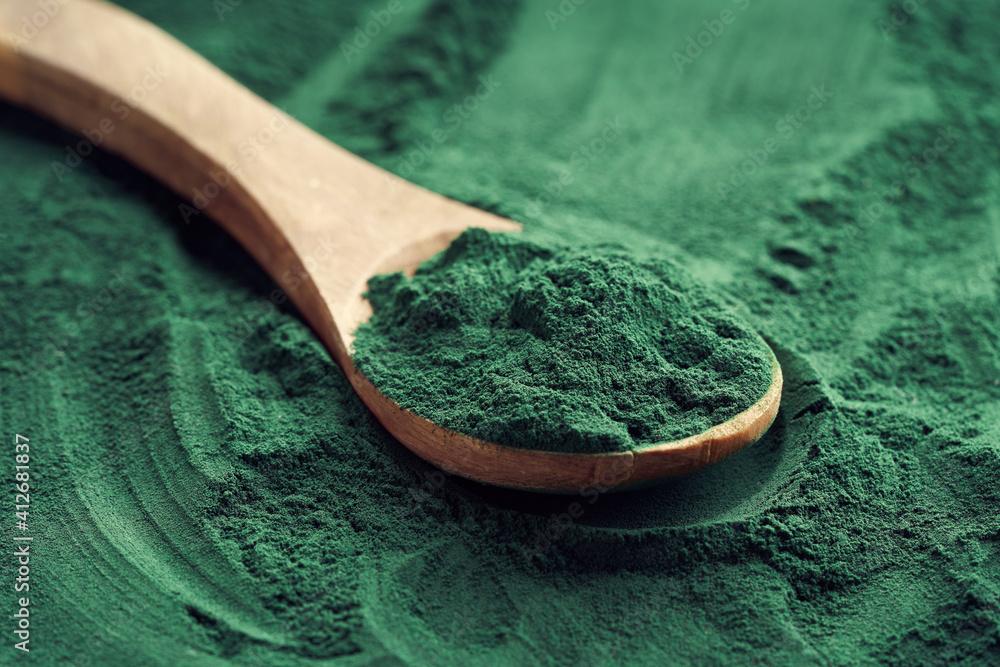close up of spirulina powder being sprinkled on tabbouleh