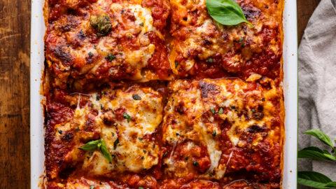 layering spicy italian sausage lasagna with jalapeños in a baking dish