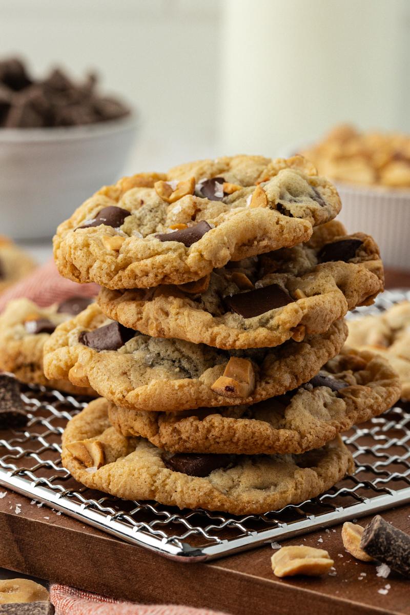 a stack of peanut butter sea salt chunk cookies with chocolate chunks oozing out