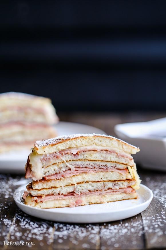 Stack of Monte Cristo Pancakes drizzled with raspberry jam and dusted with powdered sugar