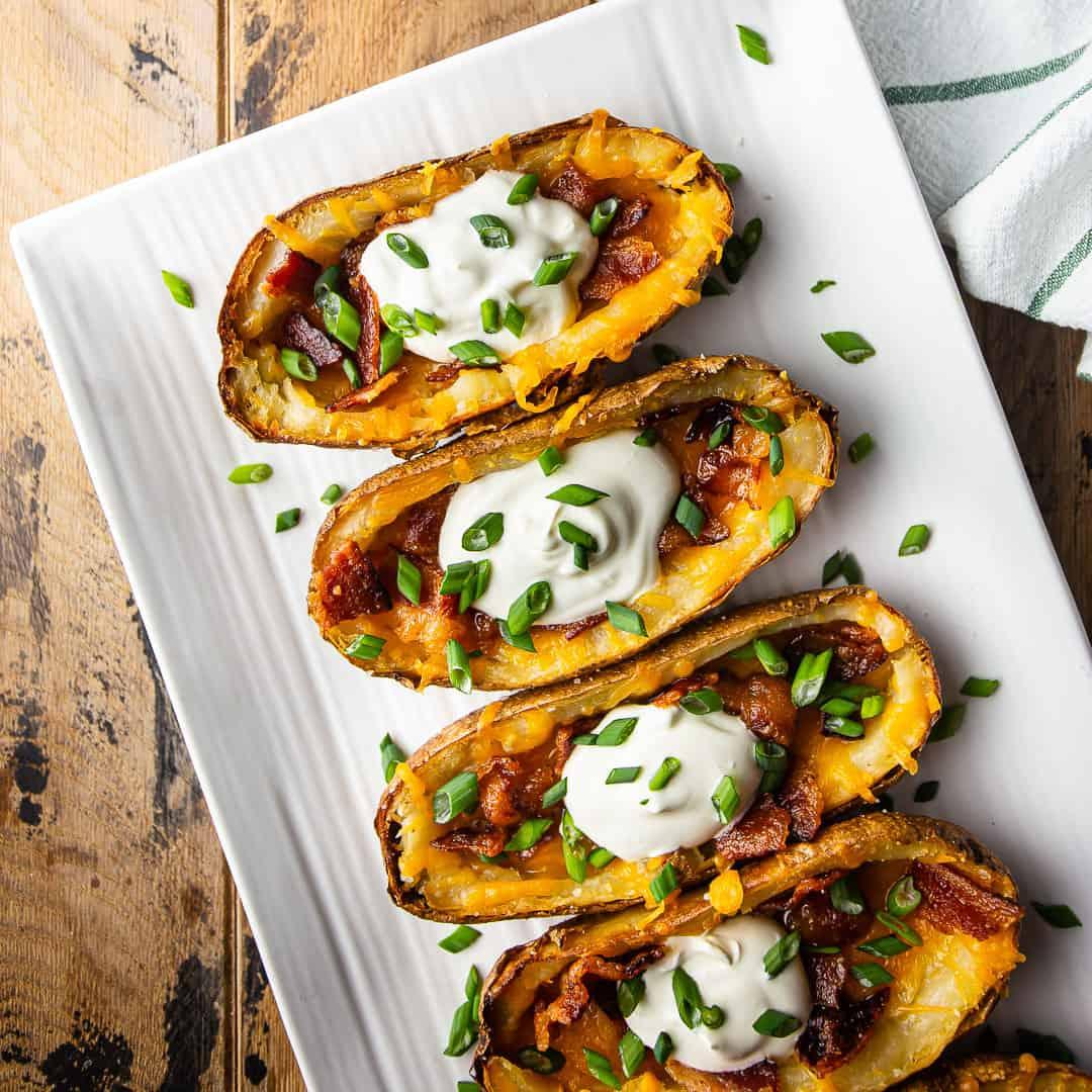 Crispy potato skins loaded with bacon and cheese, garnished with green onions