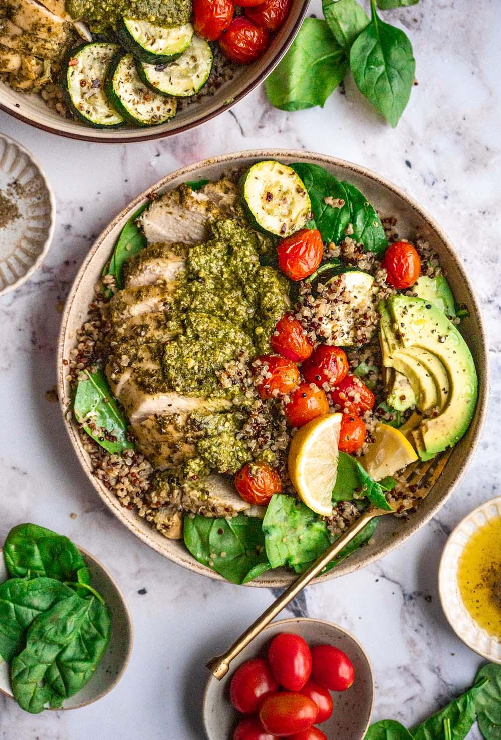 a vibrant cauliflower rice bowl with pesto, grilled chicken, and fresh herbs