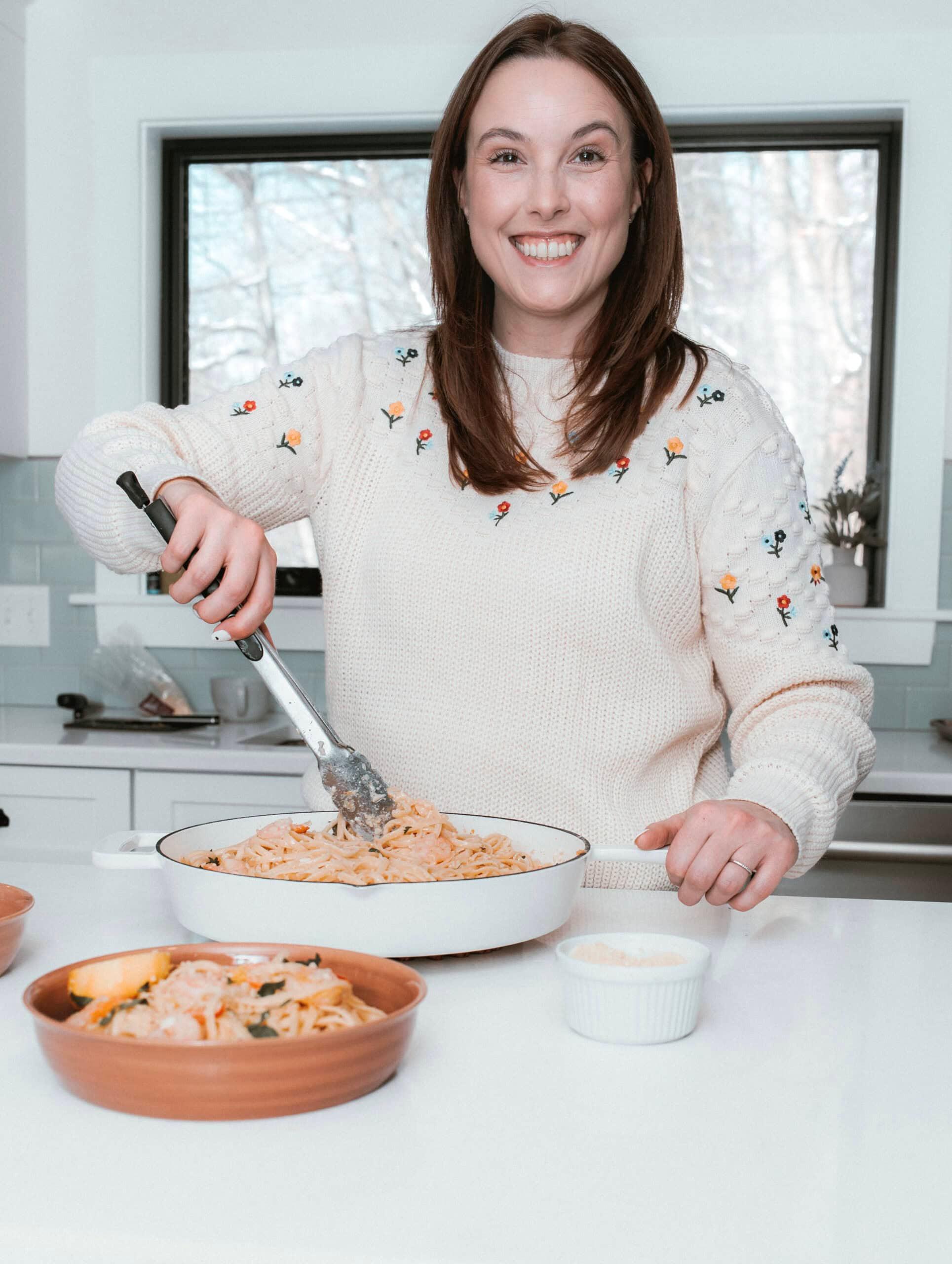 Smiling woman enjoying a fresh apple walnut salad at a bright kitchen counter