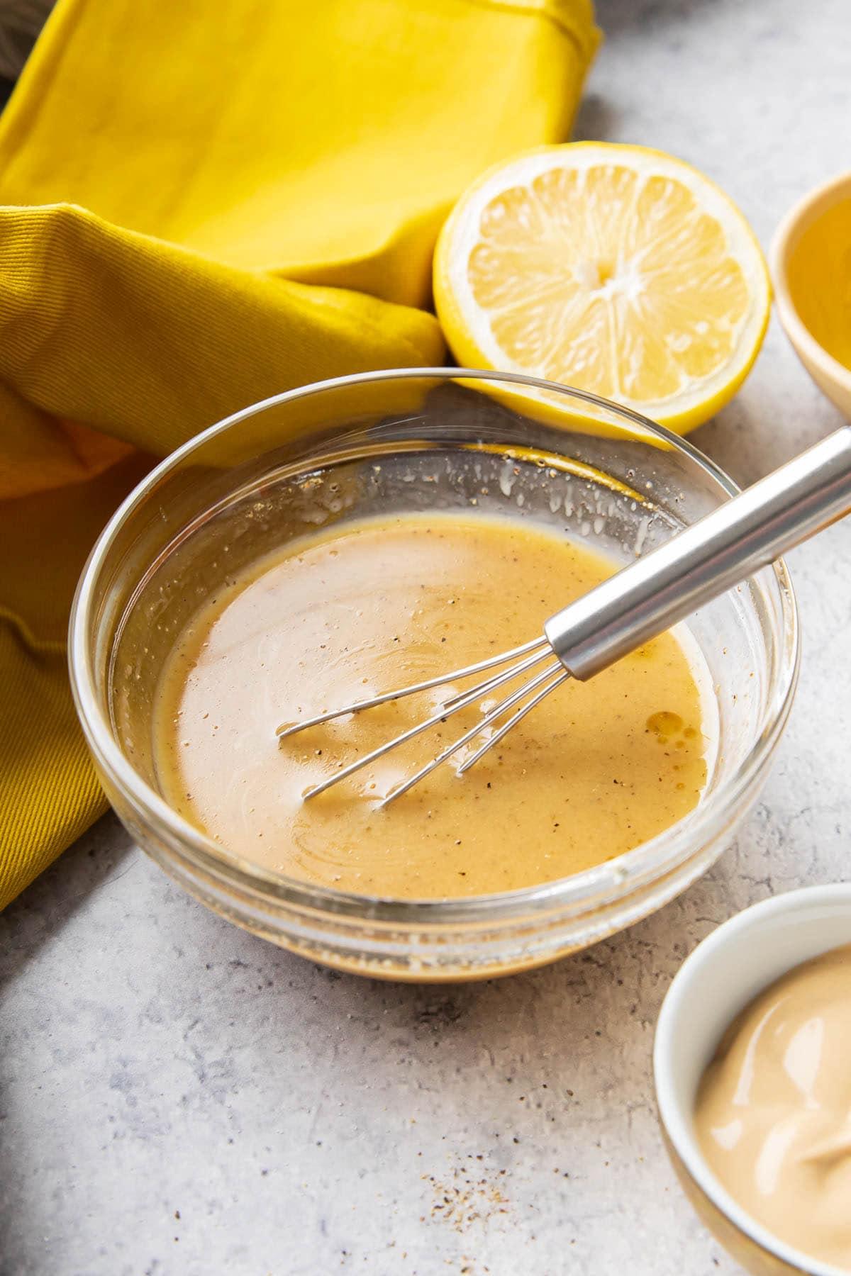 homemade honey mustard vinaigrette being whisked in a small bowl