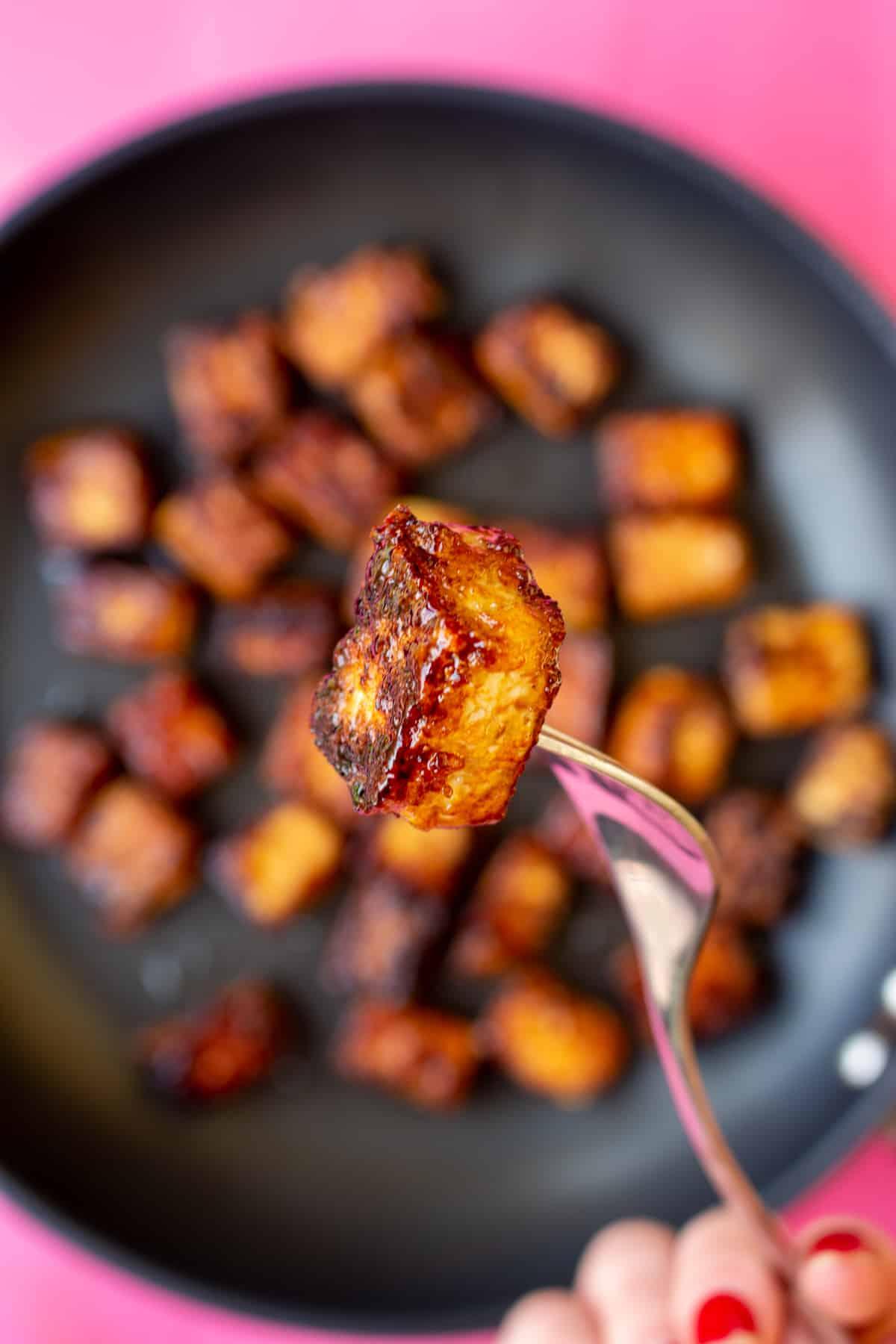Tofu cubes being pan-fried in garlic butter, close-up shot