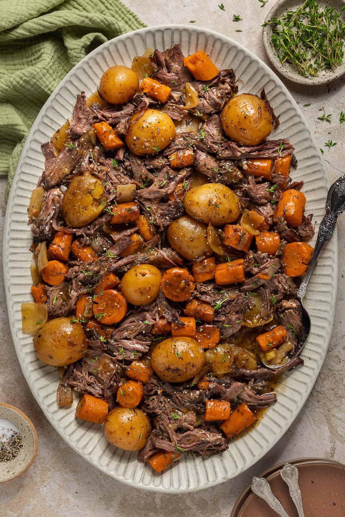 overhead shot of a pot roast with carrots, potatoes, and onions