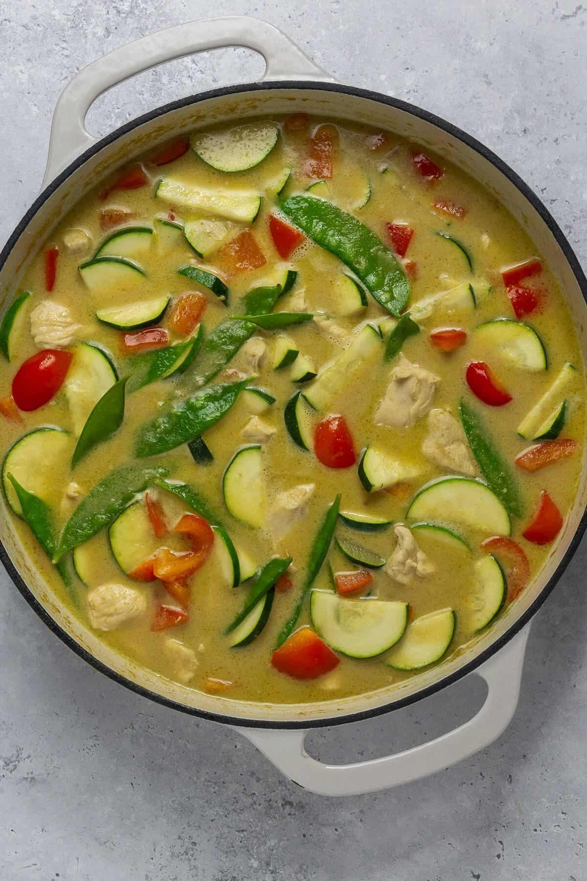 Overhead shot of a skillet with Green Curry Fish and Zucchini simmering