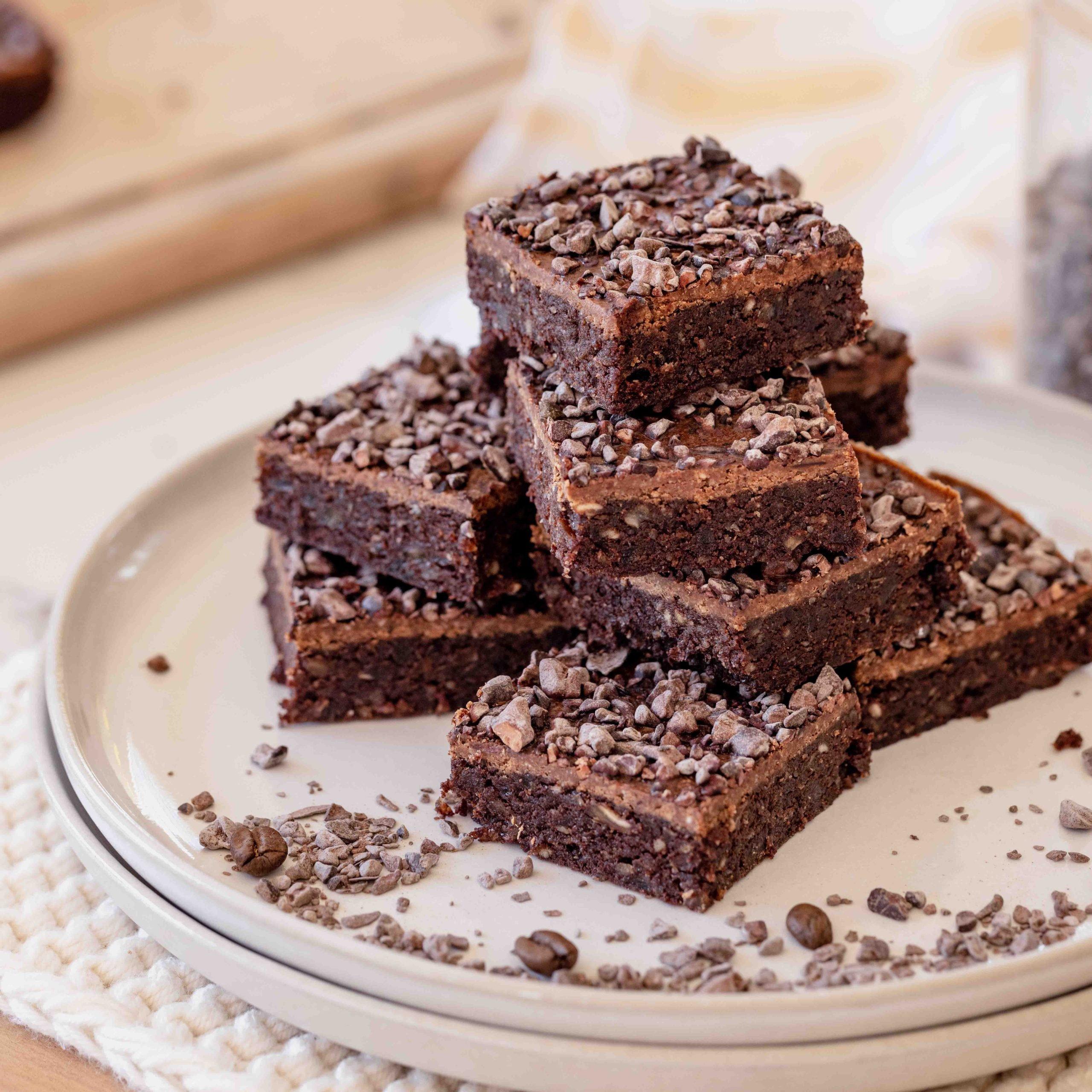 A batch of espresso brownies with ganache, displayed on a serving plate