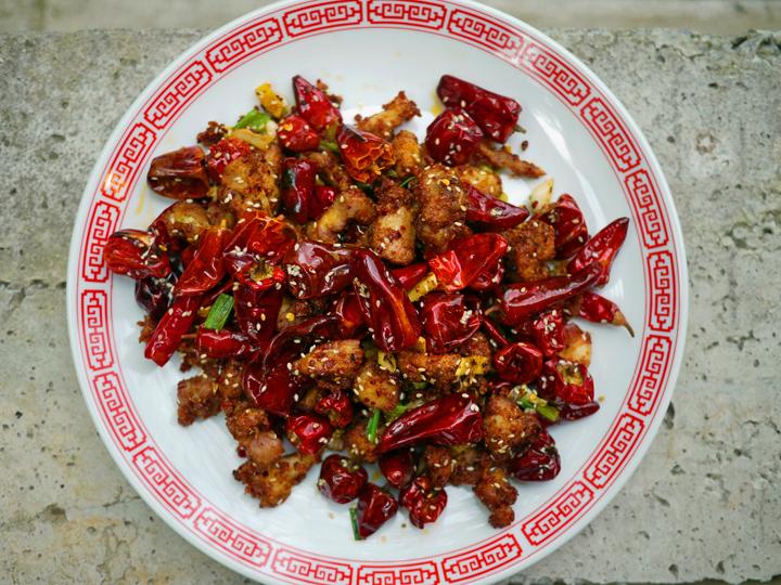 Overhead shot of Szechuan peppercorn fried chicken on a plate with chili flakes
