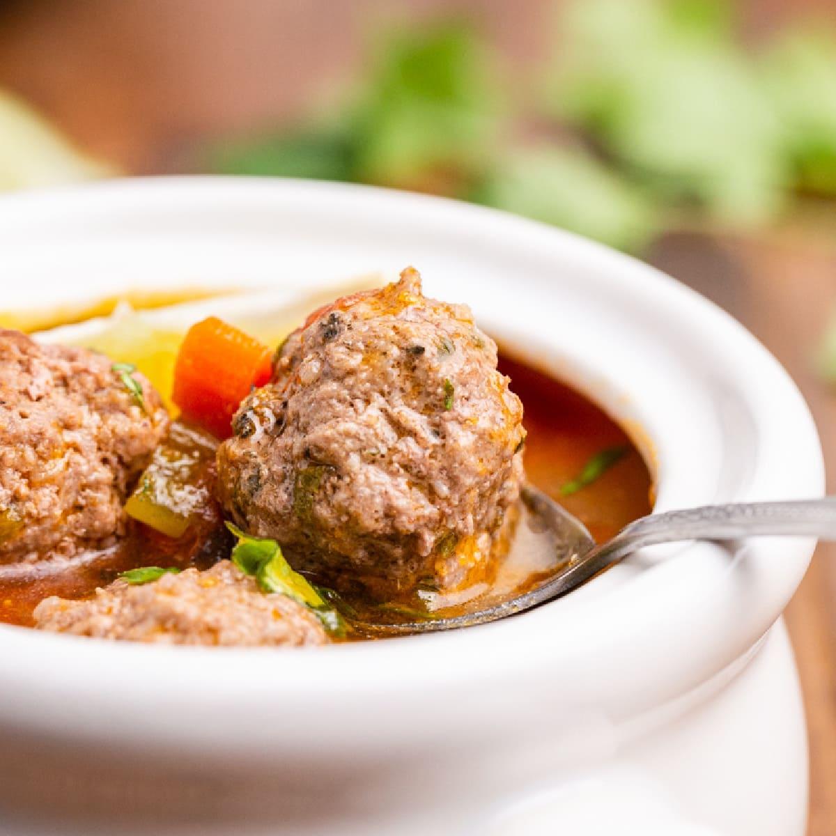 A steaming pot of keto Mexican meatball soup on a rustic wooden table