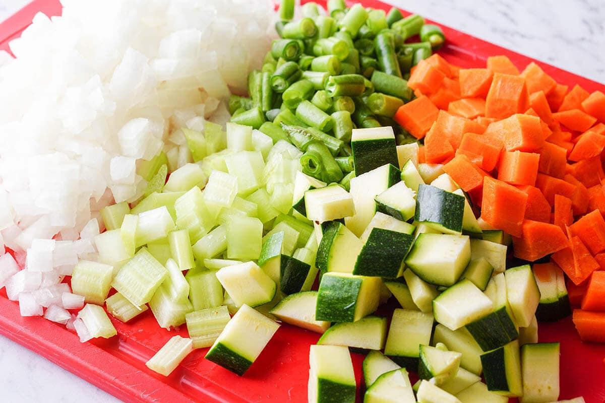 Chopped colorful vegetables on a cutting board ready for lentil stew