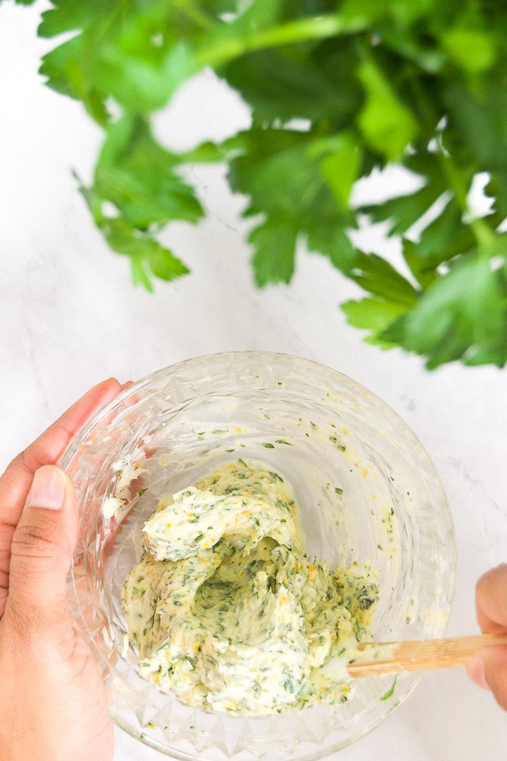 Person preparing herb and garlic compound butter for turkey