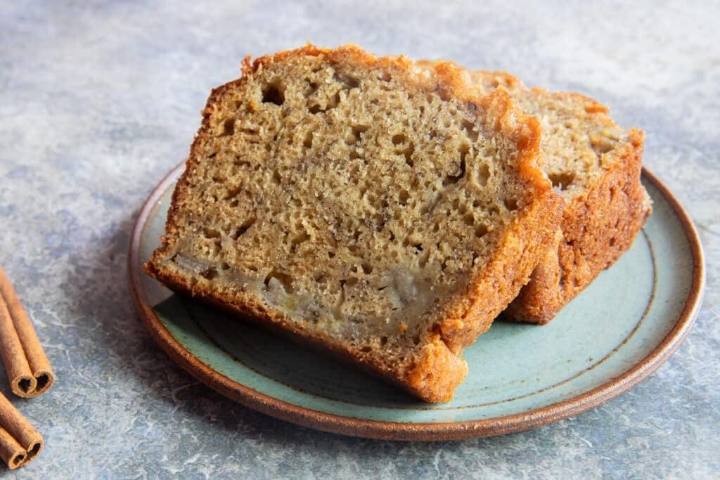 Close-up of golden brown banana spice sugar bread with a glistening sugar crust, on a rustic plate