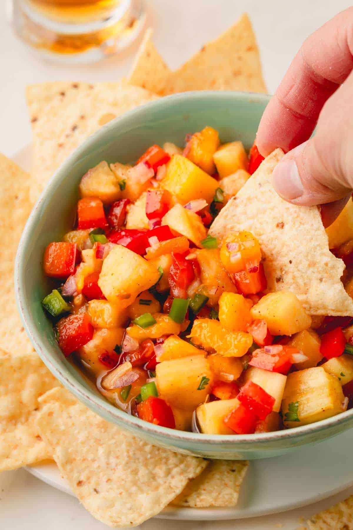 vibrant close-up of smoked paprika and pineapple salsa in a bowl with tortilla chips