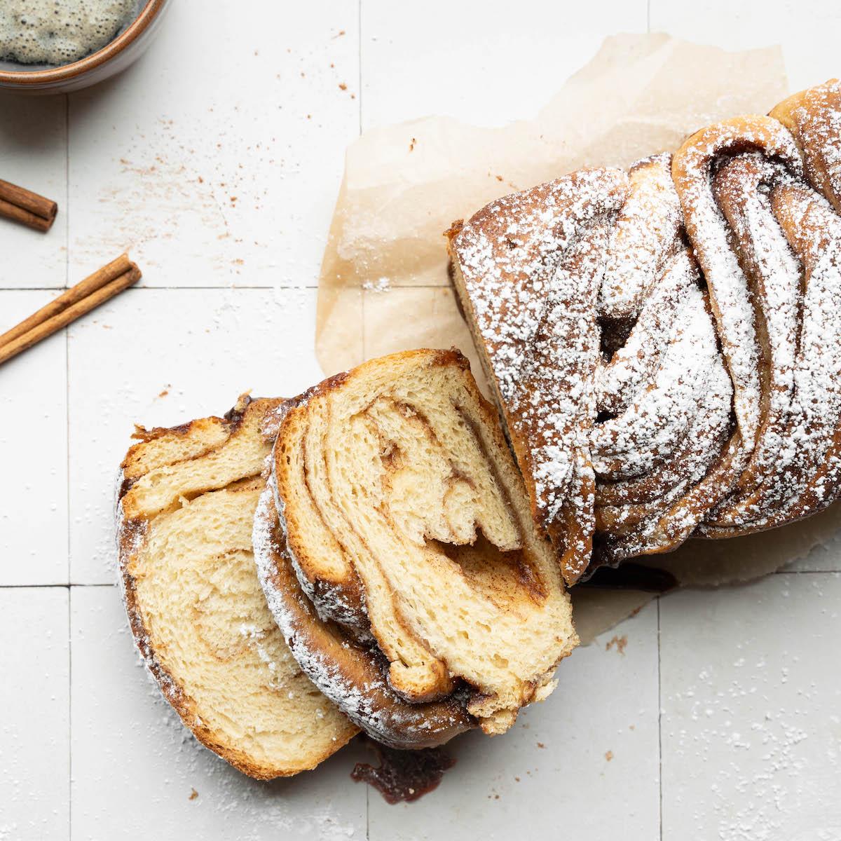 Close-up of a braided cinnamon roll loaf showing the cinnamon swirl, fresh out of the oven.