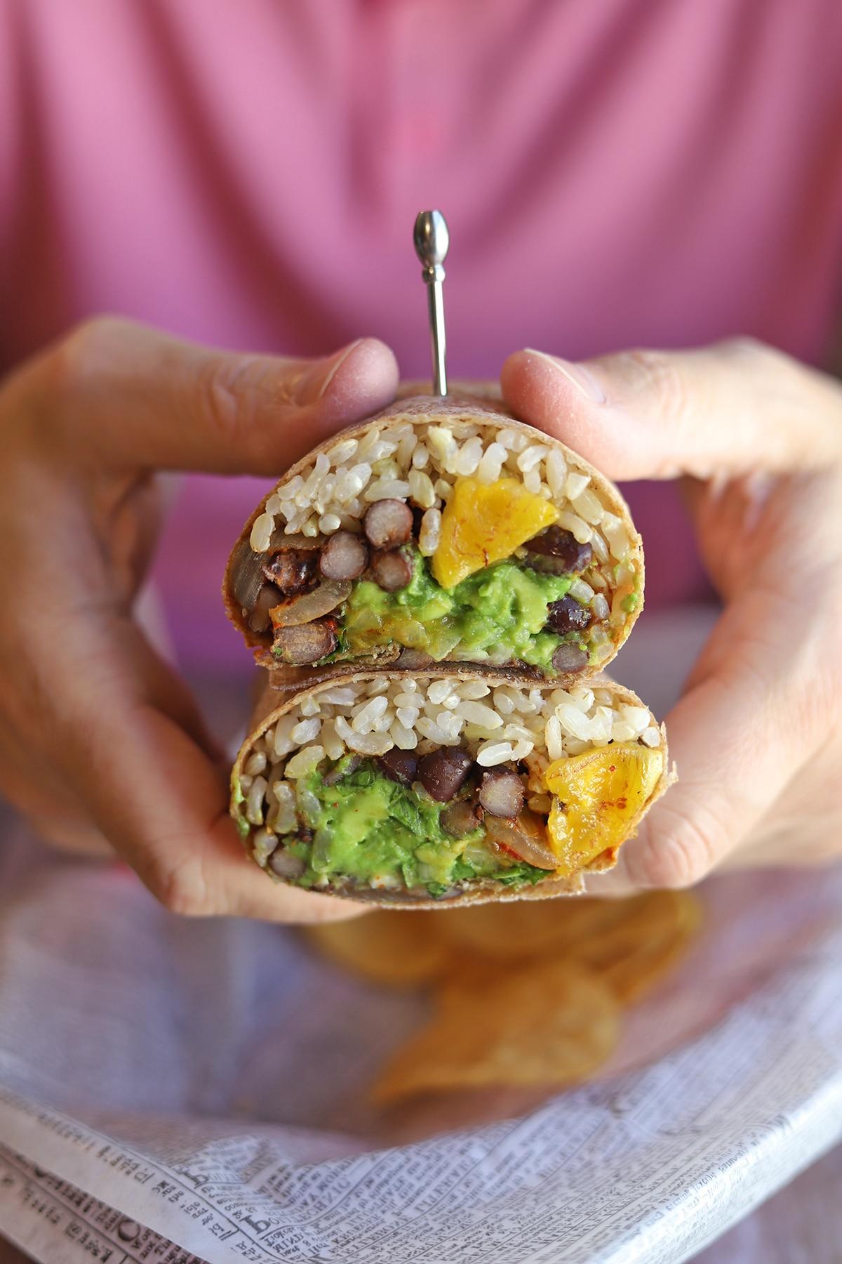 Plantain burritos with various fillings displayed on a rustic wooden table