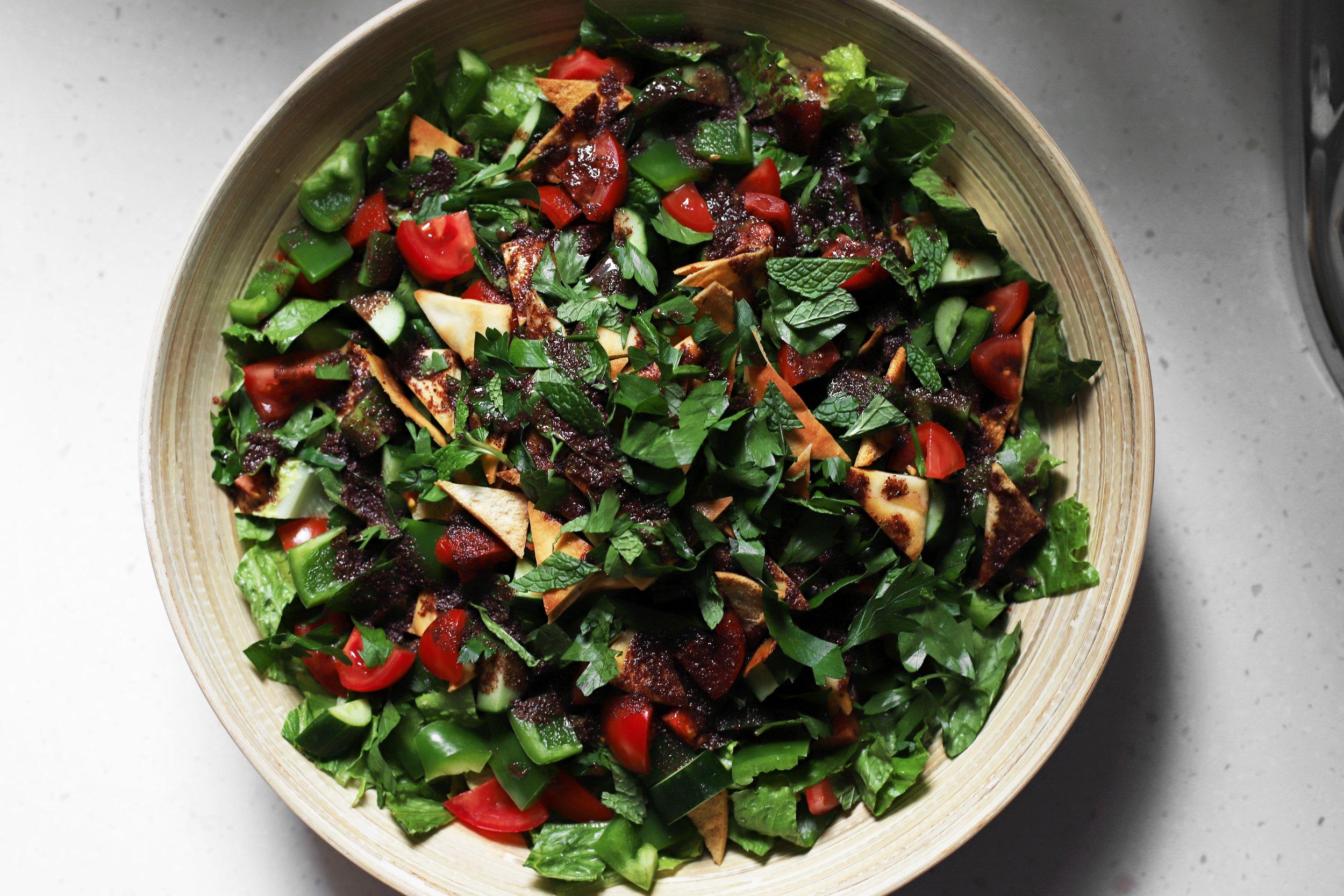coffee cardamom fattoush salad on a rustic wooden table