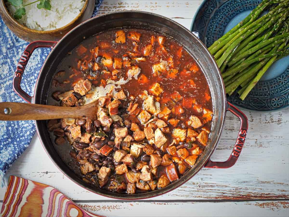 Overhead shot of feijoada simmering in a large pot on the stove