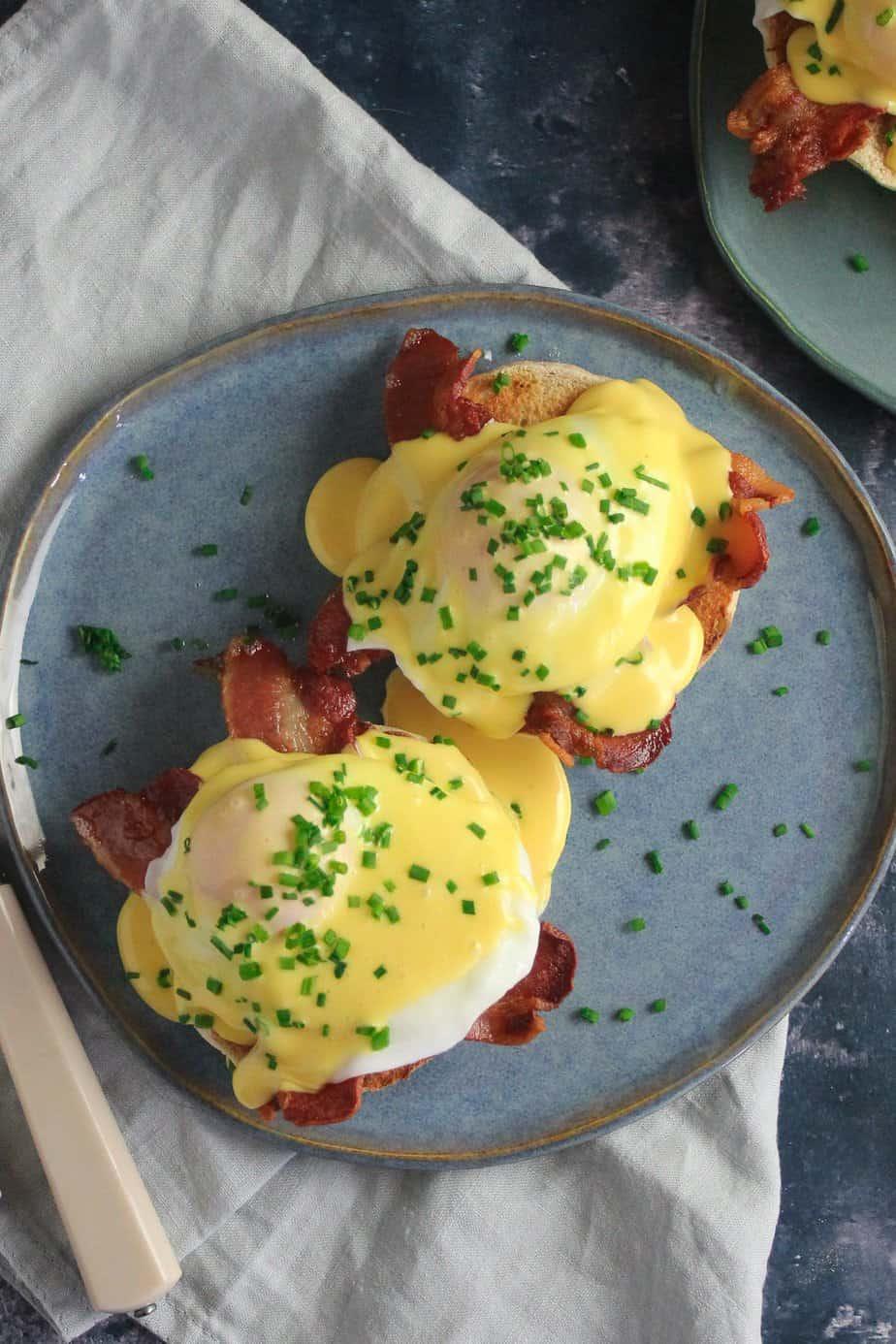 Eggs Benedict with hollandaise sauce drizzling over the eggs