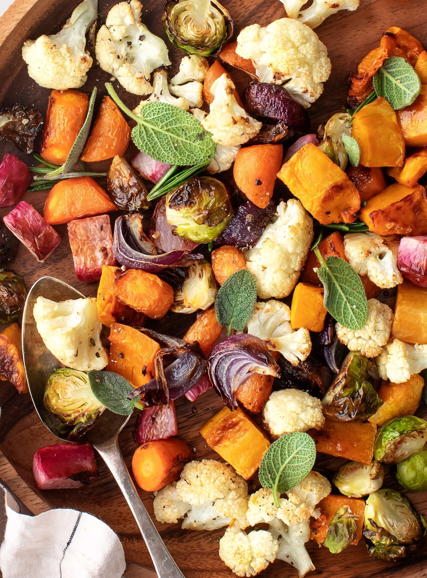 colorful mixed roasted vegetables on a baking sheet, golden brown