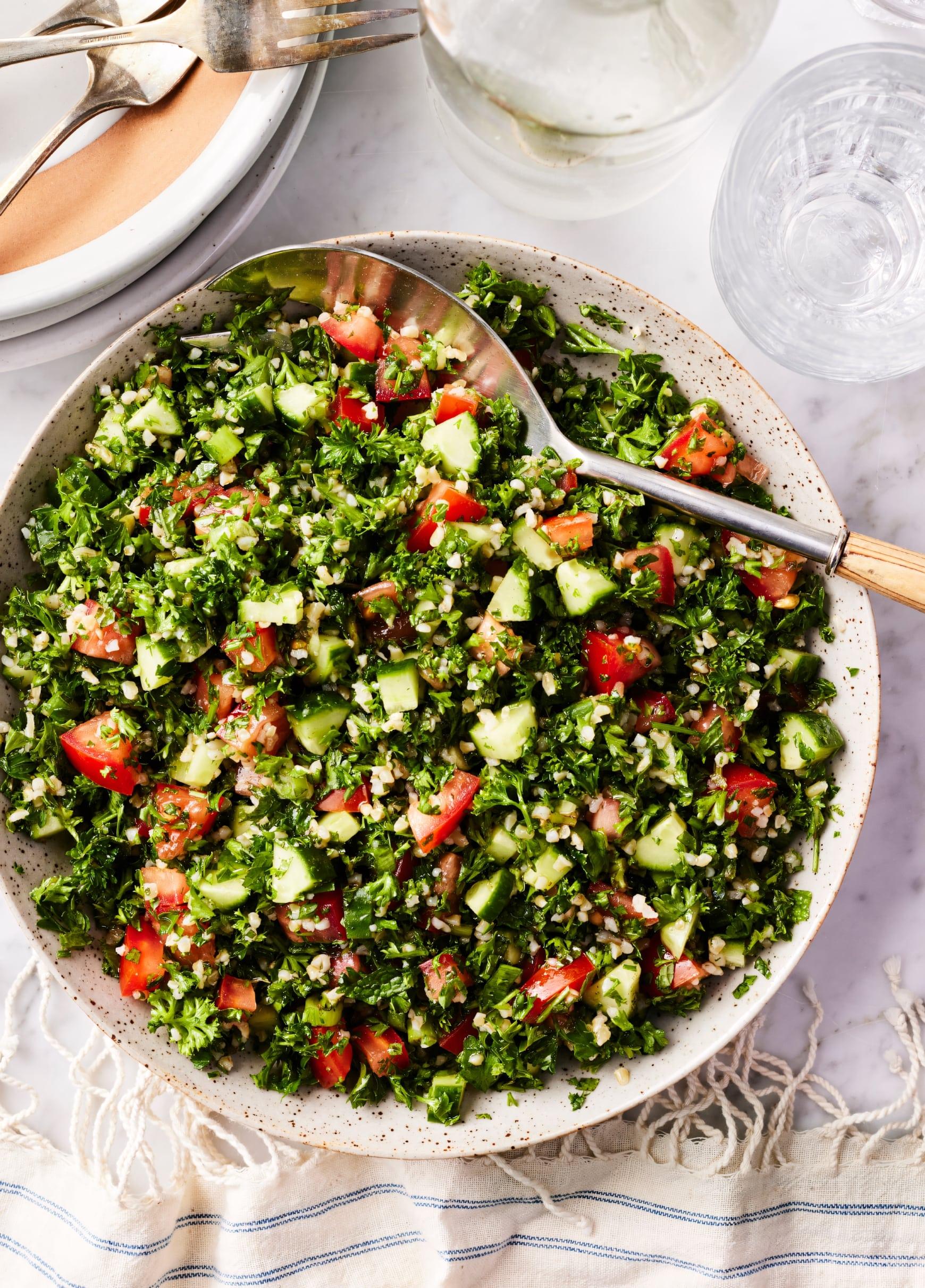 A bowl of tabbouleh salad being prepared with fresh ingredients