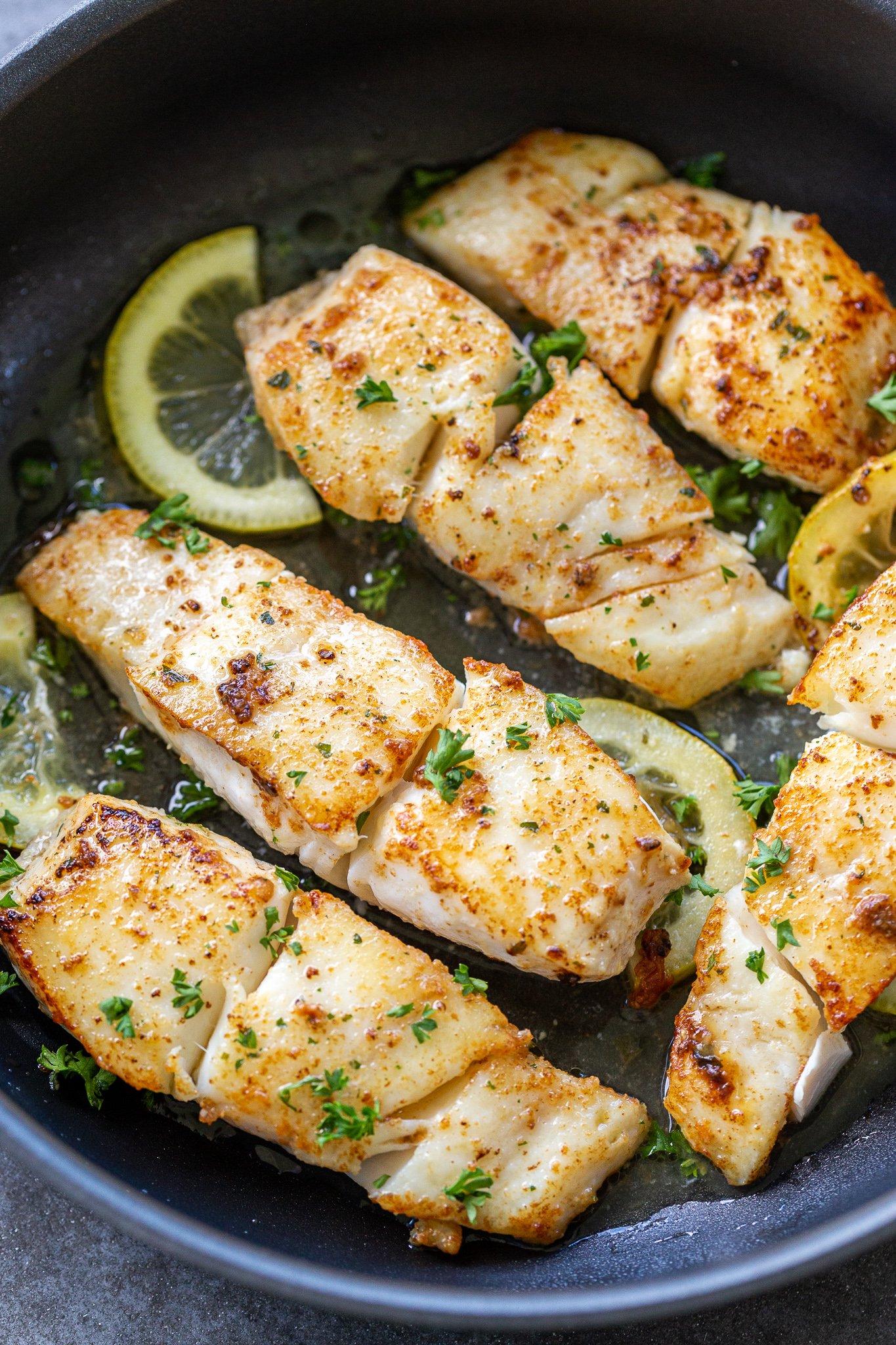 sautéed halibut being pan-seared in a skillet