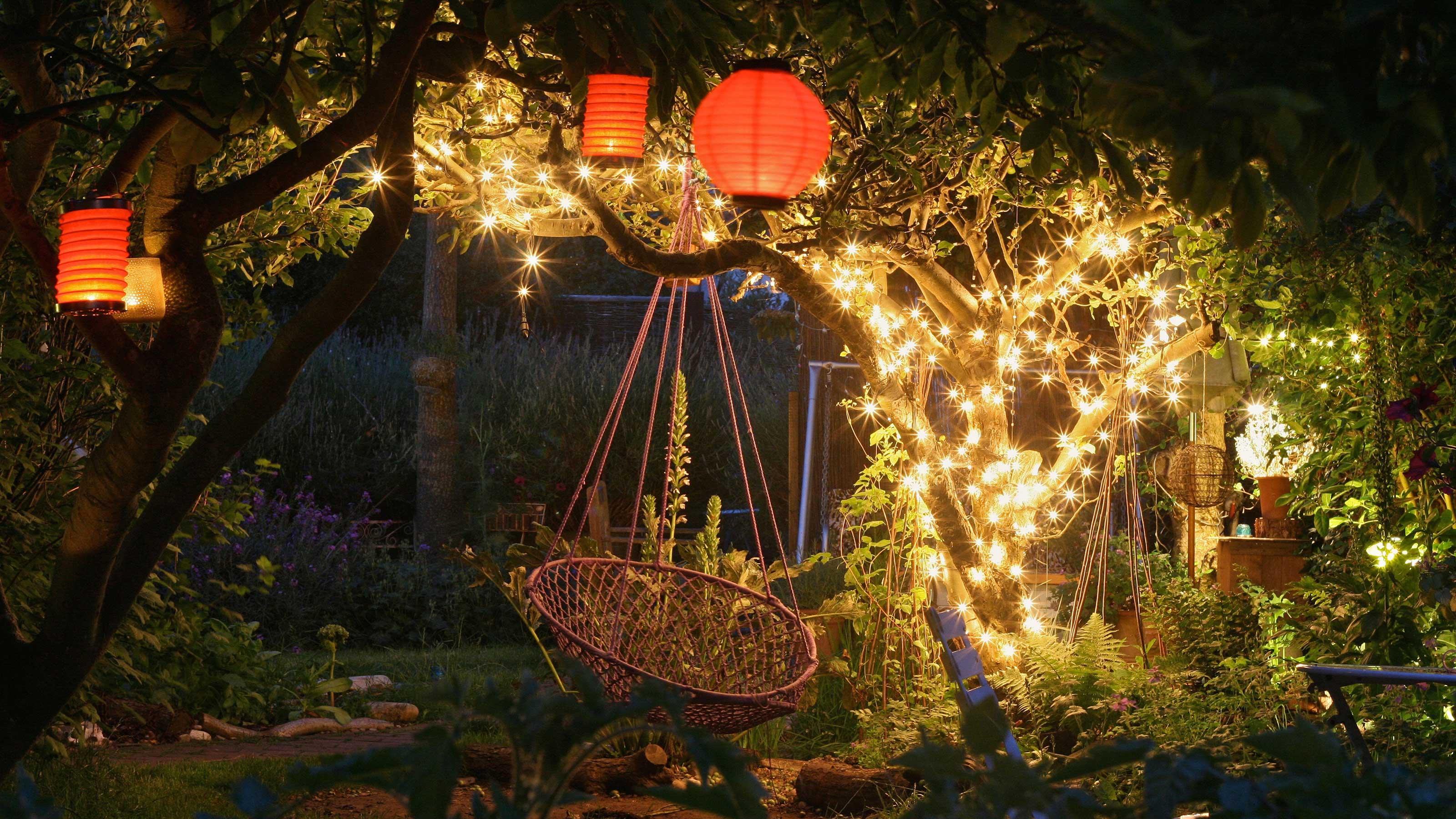 Fairy lights and lanterns creating a magical ambiance in a garden party setting