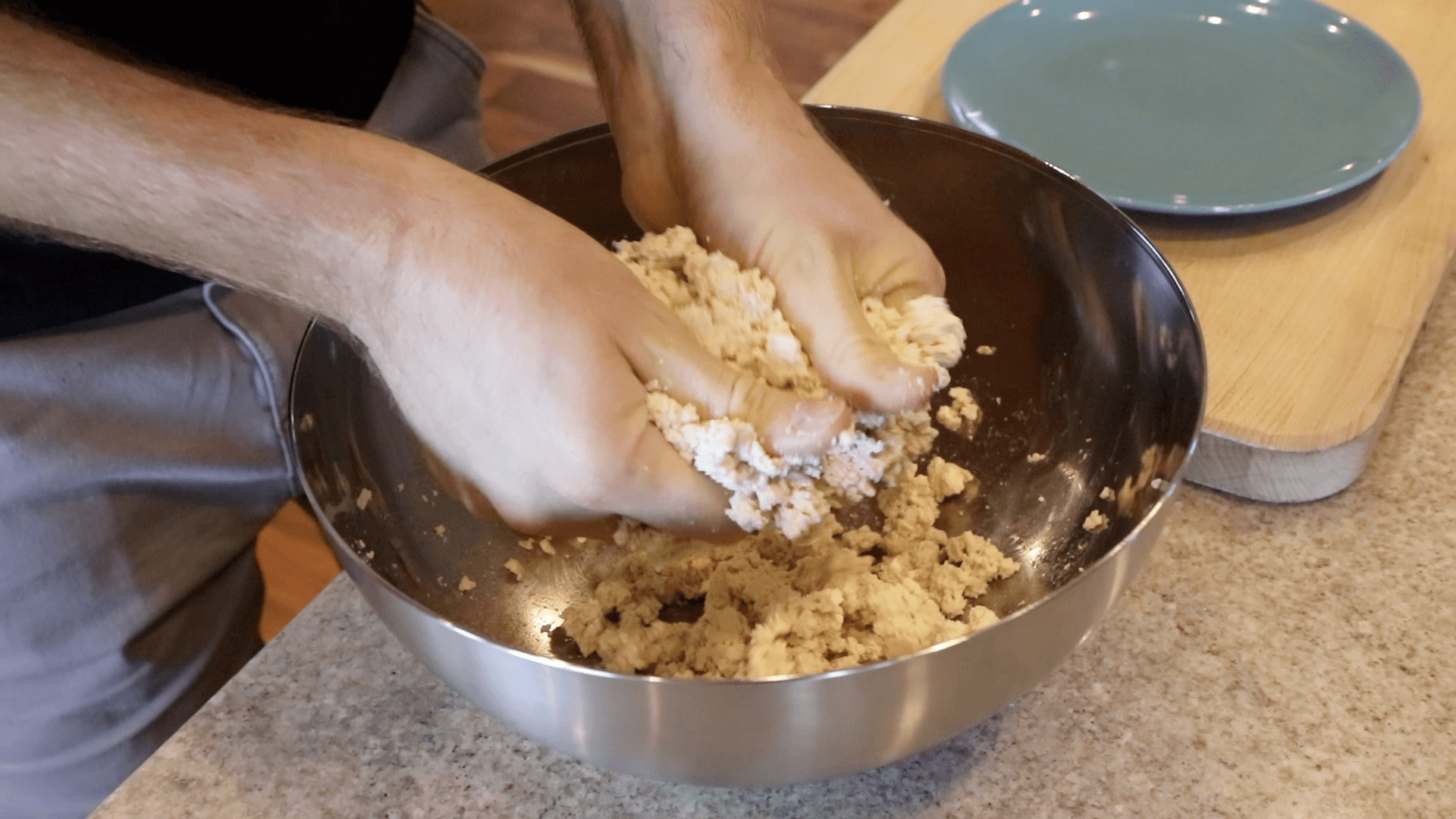 Close-up of tofu being crumbled with hands