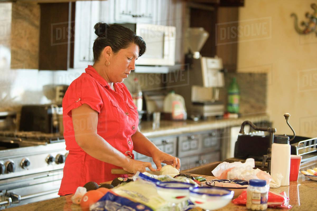 Spanish woman cooking frixuelos in a kitchen