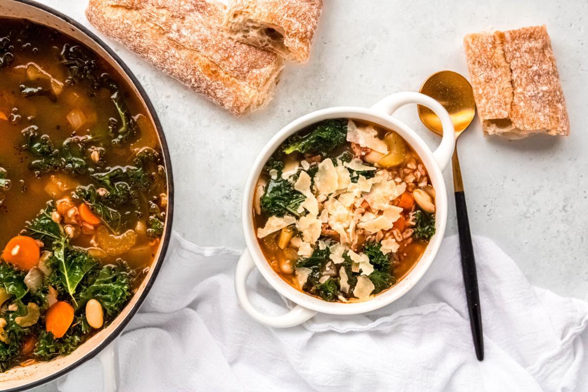 Overhead shot of a Tuscan white bean and farro grain bowl on a rustic wooden table
