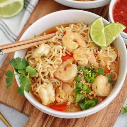 a bowl of spicy shrimp ramen viewed from above, highlighting the shrimp and cilantro