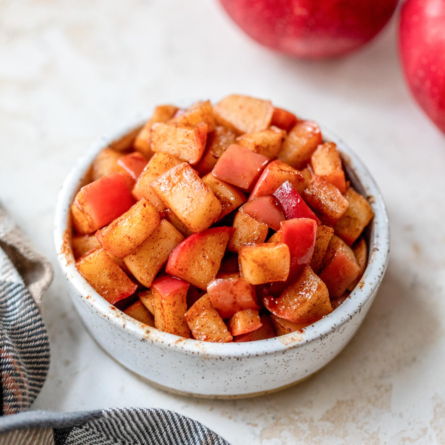 close-up of diced apples being tossed with cinnamon and sugar in a bowl