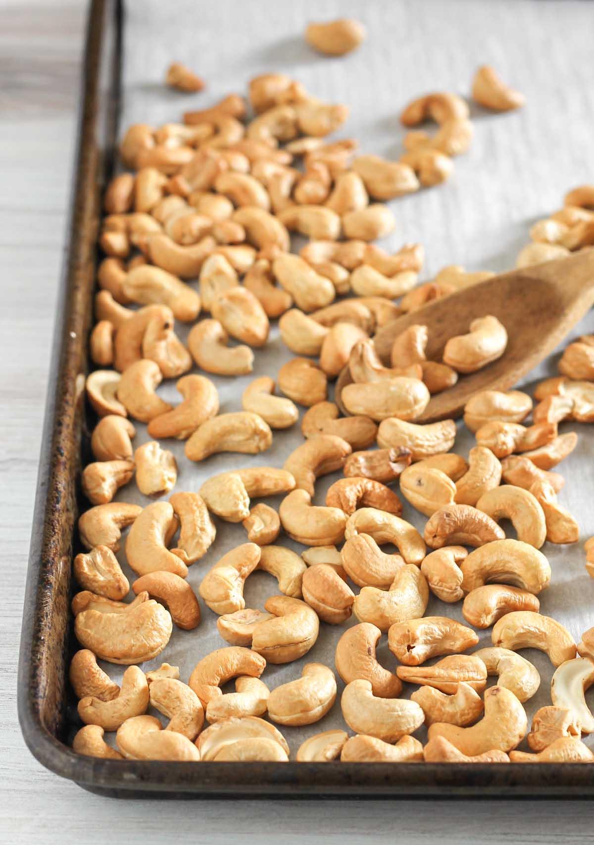 baking sheet of roasted cashews in the oven