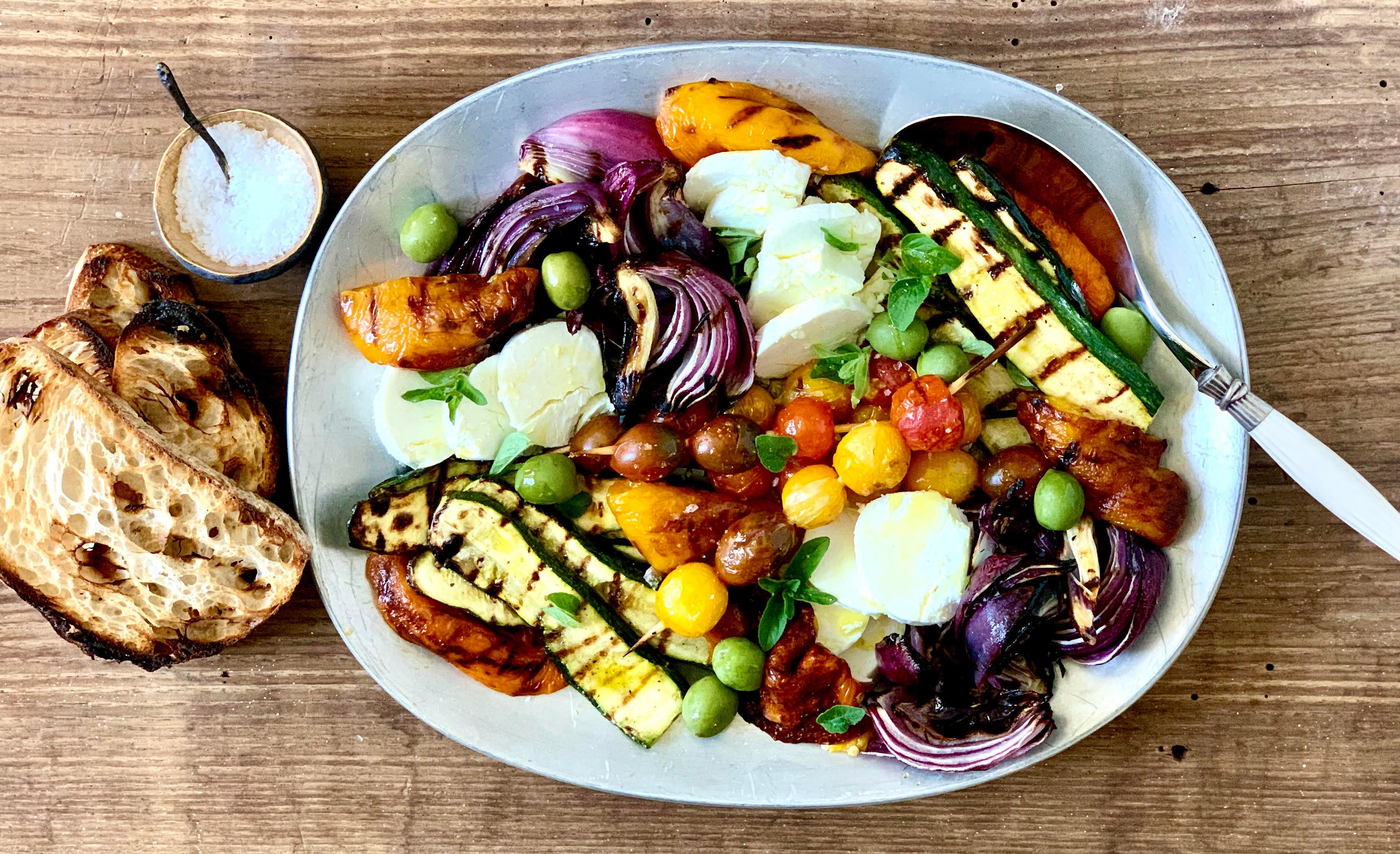 overhead shot of a colorful arrangement of grilled vegetables on a rustic wooden board