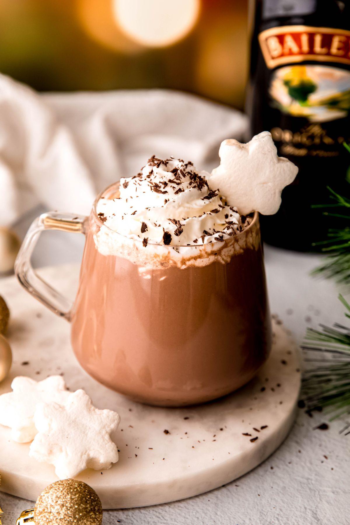 Close-up of a steaming mug of dark chocolate cocoa with a silky, frothy top and a sprinkle of chocolate shavings