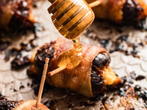 Bacon wrapped dates on a platter with sticky glaze, close-up, warm lighting