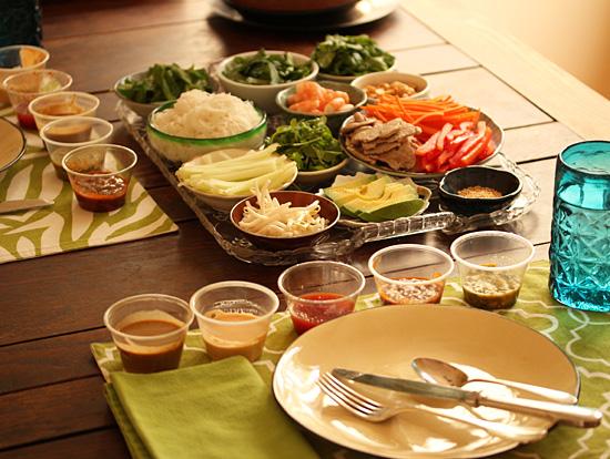 A table setting with spring rolls and dipping sauces