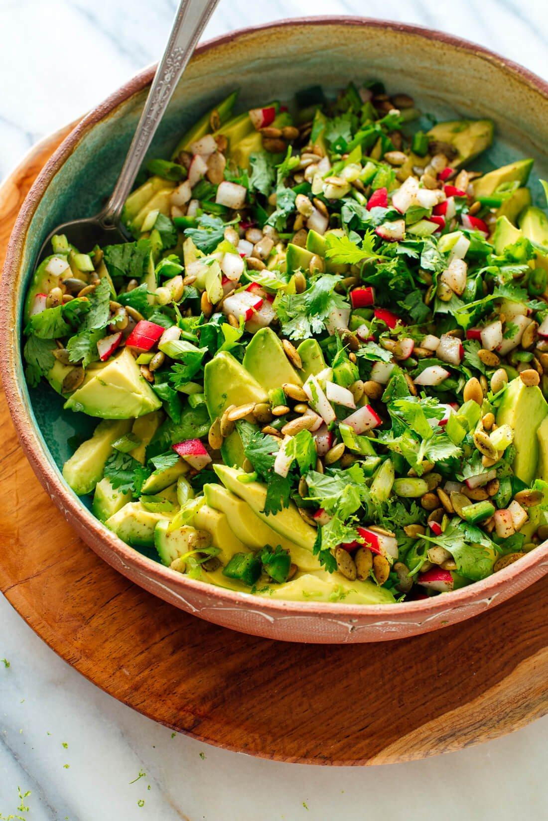 Overhead shot of the finished Keto Rutabaga Avocado Salad in a bowl, garnished with fresh herbs