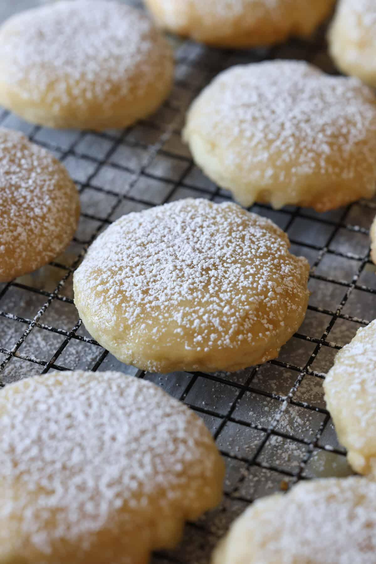 close up of soft, perfectly baked sugar cookies on a cooling rack, some with simple glaze