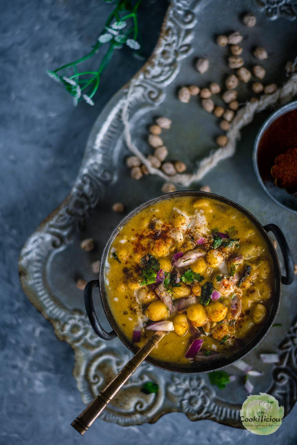 close-up shot of chickpea and artichoke curry being stirred in a pot