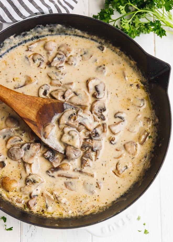 Homemade creamy mushroom sauce simmering in a skillet